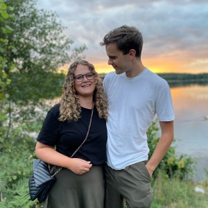 Amanda och Daniel Jennebratt en sommarkväll framför en sjö med solnedgång i bakgrunden